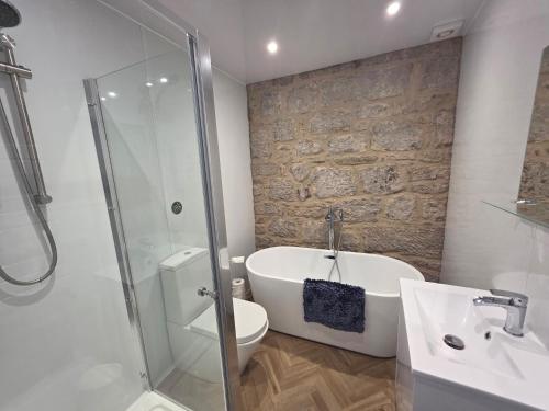 a bathroom with a tub and a toilet and a sink at Musselburgh Links B&B in Musselburgh