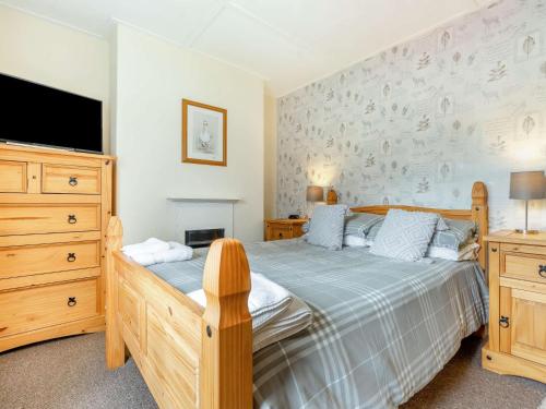 a bedroom with a bed and a dresser and a tv at 2 Bed in Kielder 89299 in Falstone