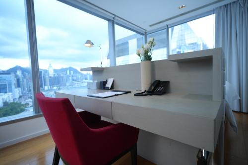 a white desk with a red chair in a room with windows at Twenty One Whitfield in Hong Kong