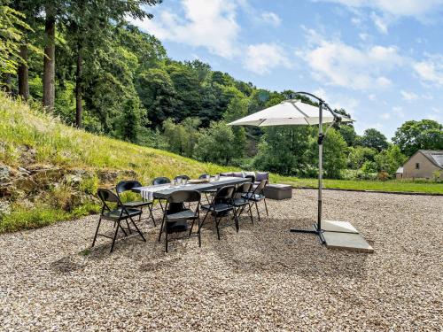 a table with chairs and an umbrella on a gravel road at 4 Bed in Old Churchstoke 91498 in Church Stoke