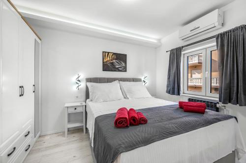 a bedroom with a bed with red slippers on it at Holiday home Vodice in Vodice