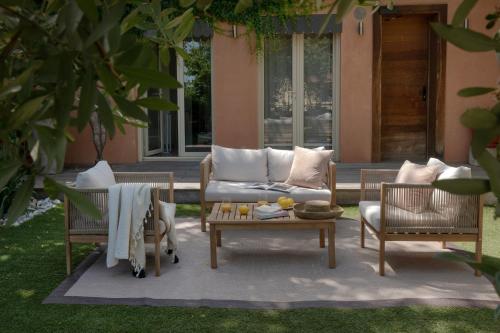 a patio with a couch and two chairs and a table at MiHotel Le Gourguillon in Lyon
