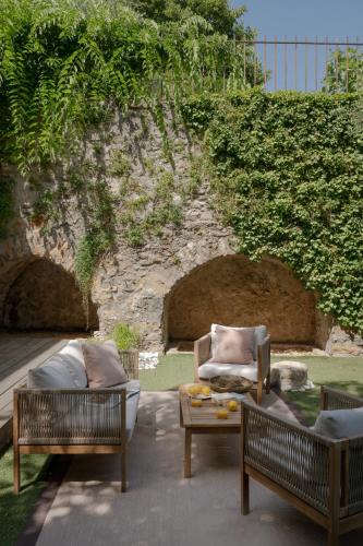 a patio with two chairs and a couch and a table at MiHotel Le Gourguillon in Lyon