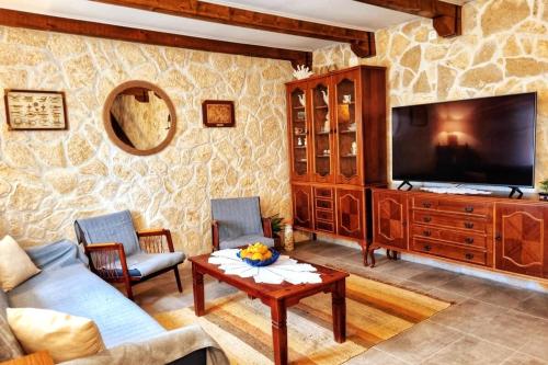 a living room with a couch and a tv at Relaxing Historic House on the Adriatic coast in Lukovo
