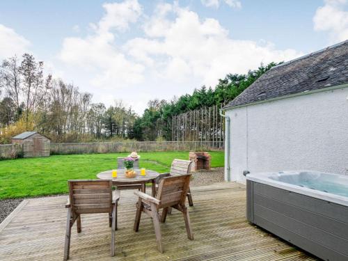 a patio with a table and chairs and a tub at 2 Bed in Ayr 90039 in Ayr