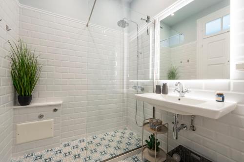a white bathroom with a sink and a mirror at Agora apartment in Ermoupoli