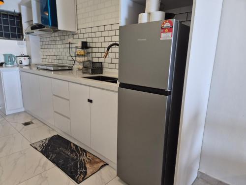 a refrigerator in a kitchen with a floor grate at 13pax BAYU EXECUTIVE SUITE 3R2B, SEASIDE, ROOFTOP BBQ, WATERSPORT, Pool, Wifi, 50"TV in Port Dickson