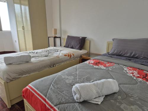 two beds sitting next to each other in a room at 13pax BAYU EXECUTIVE SUITE 3R2B, SEASIDE, ROOFTOP BBQ, WATERSPORT, Pool, Wifi, 50"TV in Port Dickson