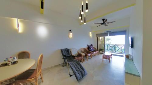 a living room with a table and chairs at 13pax BAYU EXECUTIVE SUITE 3R2B, SEASIDE, ROOFTOP BBQ, WATERSPORT, Pool, Wifi, 50"TV in Port Dickson