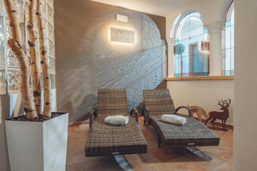 a room with two chairs and a wall with a mural at Aparthotel Majestic in Predazzo