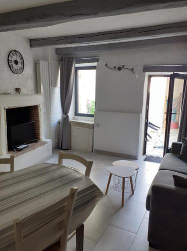 - un salon avec une table et une horloge murale dans l'établissement Lovely cosy house, à La Flotte