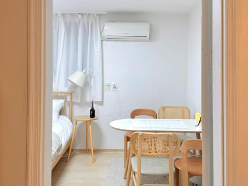 a room with a table and chairs and a bed at Song-i stay & in Seoul
