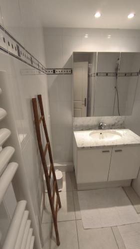 une salle de bain blanche avec un lavabo et des toilettes dans l'établissement Côté Port, à La Ciotat