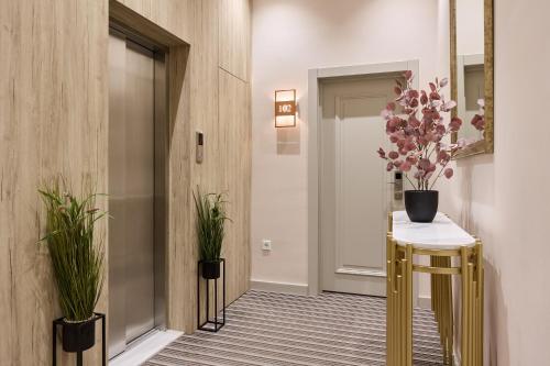 a hallway with a table with flowers on it at Maestro Address Baku Hotel in Baku