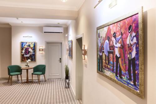 a hallway with a large painting on the wall at Maestro Address Baku Hotel in Baku