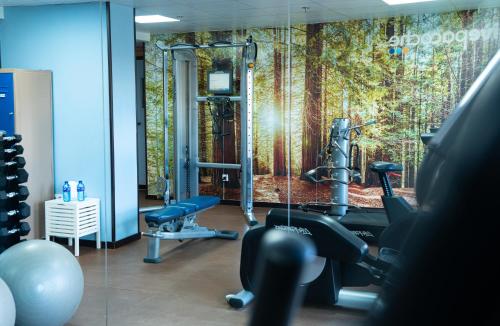 a room with a gym with a wall mural of trees at Pacoche Murcia in Murcia