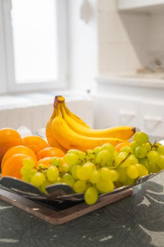 une assiette de fruits sur un comptoir avec des bananes et des oranges dans l'établissement Maison CALAIS centre ville L, à Calais