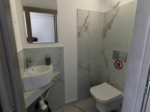 a bathroom with a toilet and a sink at Sunny Nest Apartments in Ixia