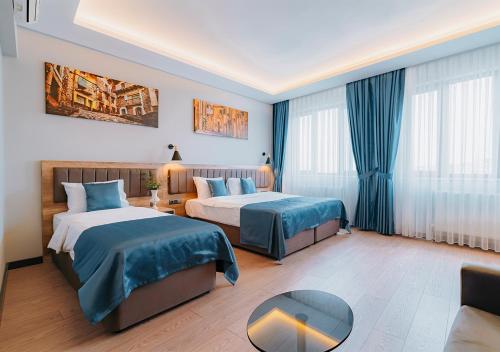 a hotel room with two beds and a table at City Port Hotel Trabzon in Trabzon