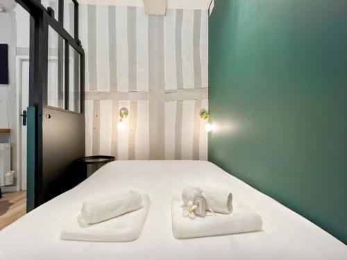 - une chambre dotée d'un lit blanc avec des serviettes et des animaux rembourrés dans l'établissement La Perle Rennaise - Calme, Élégant, Cœur de Rennes, à Rennes