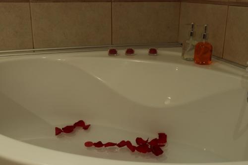 a white bath tub with red bows on the floor at Kallithea View in Prasás