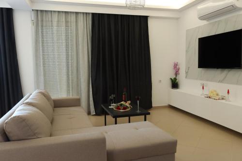 a living room with a couch and a flat screen tv at Kallithea View in Prasás