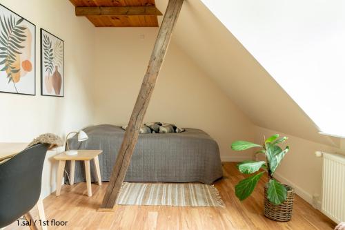 a bedroom with a bed in a attic at Akaciegaarden Bed & Breakfast in Hårlev