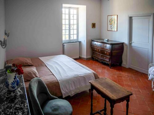 1 dormitorio con 1 cama, vestidor y silla en Villa familiale près de Laure-Minervois avec piscine, en Laure-Minervois