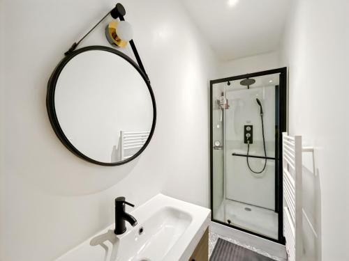 une salle de bain avec un miroir et un lavabo dans l'établissement La Perle Rennaise - Calme, Élégant, Cœur de Rennes, à Rennes