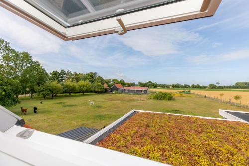 an open patio with a view of a field and a farm at Welcome in - Vakantiewoning Jikkemien met terras, vrij uitzicht en huisdiervriendelijk in Koudekerke