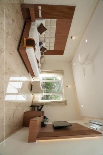 a loft bedroom with a bed and a window at Sukhi A Luxury Stay Inn in Chikmagalūr