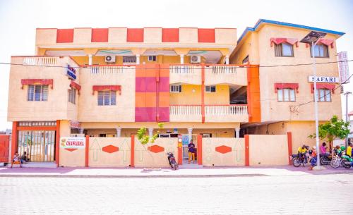 a building with a colorful facade on a street at Hotel Safari COTONOU in Cotonou
