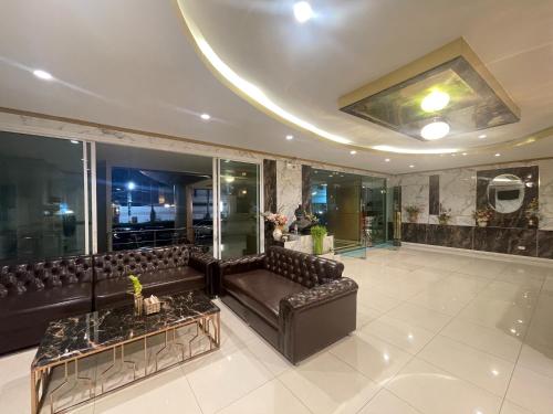 a living room with a couch and a table at Carpediem Hotel in Rayong