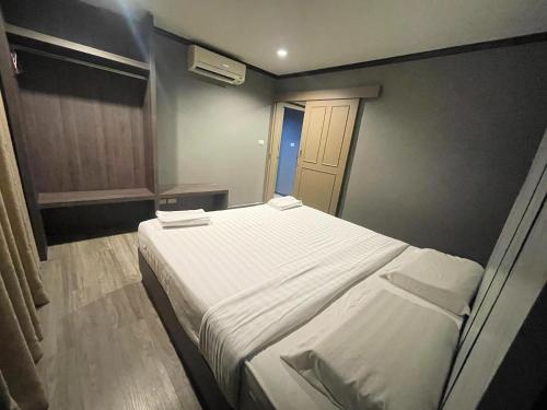 a bedroom with a large white bed in a room at Carpediem Hotel in Rayong