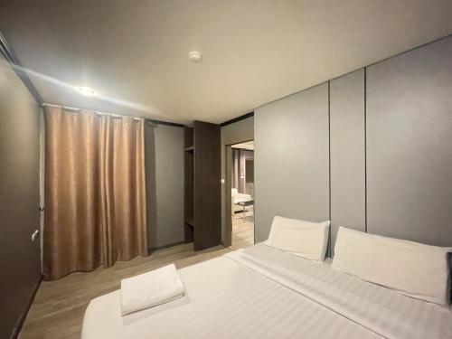 a bedroom with a large bed with white pillows at Carpediem Hotel in Rayong