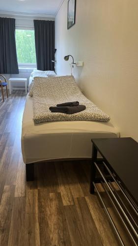 a bedroom with a bed with a lamp and a table at Rentalux Hostel - Budget Double & Single rooms in Timrå