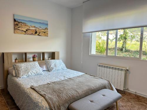 a bedroom with a bed and a window at Casa para 10 personas junto a la playa entre Combarro y Sanxenxo "Casa Saqueta" in Pontevedra
