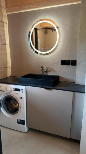 a bathroom with a sink and a washing machine at Drewno i Len in Debina