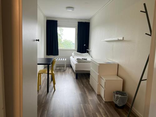 a room with a desk and a bed and a window at Rentalux Hostel - Budget Double & Single rooms in Timrå