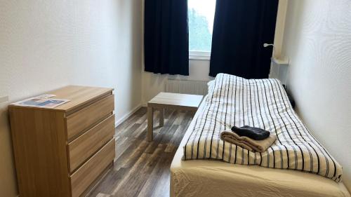 a room with a bed and a dresser next to a window at Rentalux Hostel - Budget Double & Single rooms in Timrå