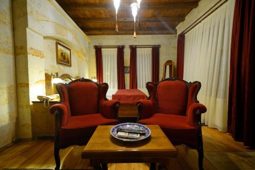 a living room with red chairs and a table at Harman Cave Hotel in Goreme