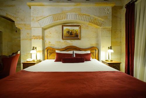 a bedroom with a large bed with red pillows at Harman Cave Hotel in Goreme
