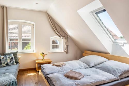 a bedroom with a bed and a couch at Der Flusshof, Ferienhaus in Werben