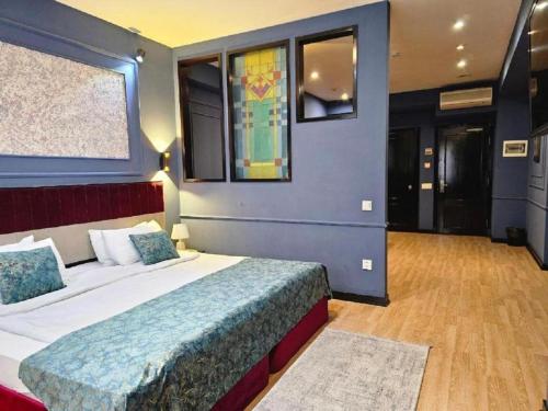 a bedroom with a large bed with a blue wall at Haz Boutique Hotel Baku in Baku