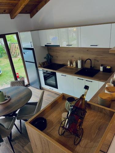 a kitchen with a bottle of wine on a wooden table at Apartman Nika in Tjentište