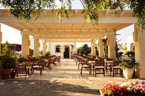 a patio with tables and chairs under a pavilion at Borgo Mulino a Vento - Resort in Uggiano la Chiesa