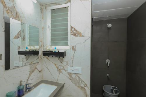 a bathroom with a sink and a mirror at Airport Runway View from terrace,Coffee Maker,Luxe in Pune