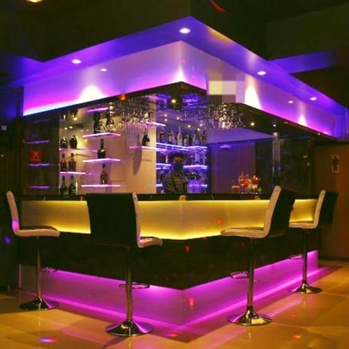 a bar with purple lights in a room at Majestic Mano in Shillong