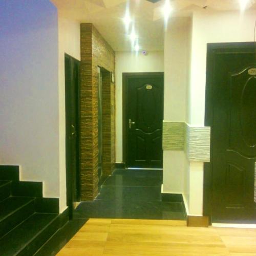 a hallway with two black doors in a building at Majestic Mano in Shillong