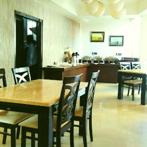 a dining room with a wooden table and chairs at Majestic Mano in Shillong